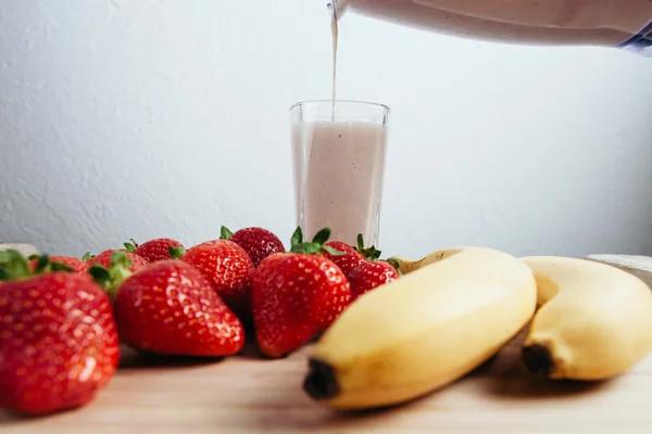 Strawberry banana smoothie fresh blended on wood table — Stock Photo, Image