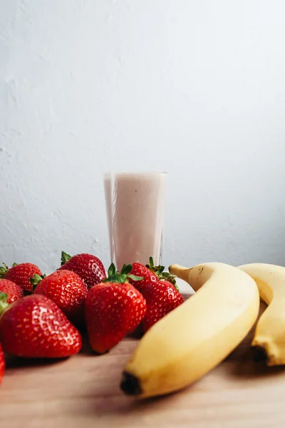 Strawberry banana smoothie fresh blended on wood table — Stock Photo, Image