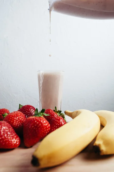 Strawberry banana smoothie fresh blended on wood table — Stock Photo, Image