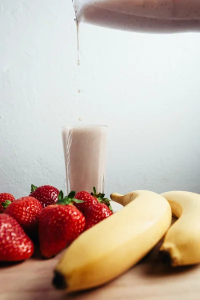 Strawberry banana smoothie fresh blended on wood table — Stock Photo, Image