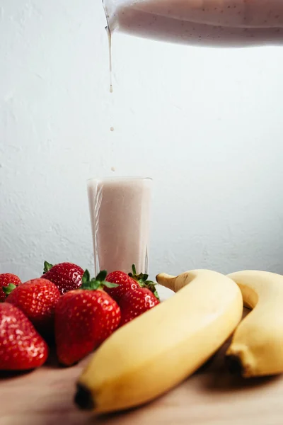 Świeży banan truskawka koktajl mieszane na stół z drewna Obrazy Stockowe bez tantiem