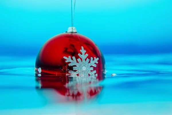 Decoración del árbol de año nuevo que fluye en el agua azul — Foto de Stock