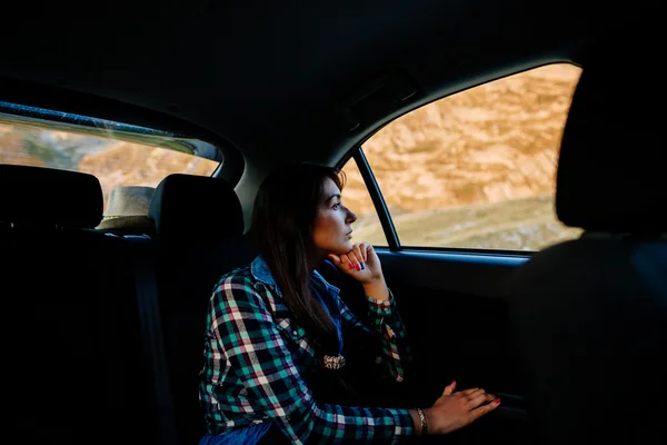 Mujer viaja y sueña en coche en las montañas —  Fotos de Stock