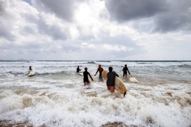 kimliği belirsiz kadın sörfçü ile sörf tahtaları denize geliyor