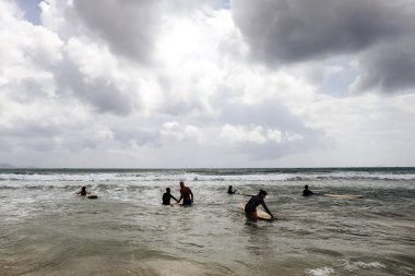 kimliği belirsiz kadın sörfçü ile sörf tahtaları denize geliyor