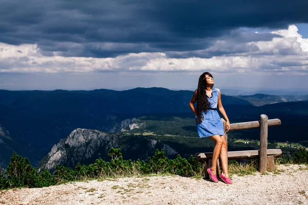 Woman relax on peak of mountain with rainy sky — Stock Photo, Image