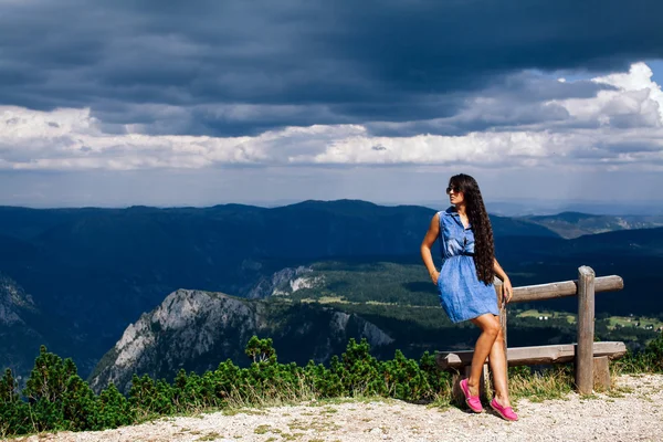 Mulher relaxar no pico da montanha com céu chuvoso — Fotografia de Stock