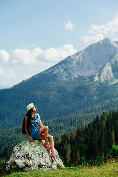 Mujer relajarse en el pico de la montaña con vistas pintorescas — Foto de Stock