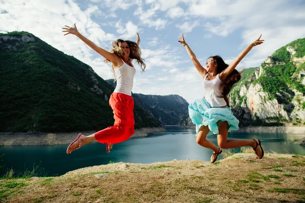 幸せな二人の少女が山でジャンプします。 — ストック写真
