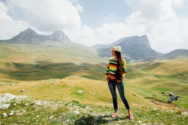 Mujer relajarse en el pico de la montaña con vistas pintorescas — Foto de Stock