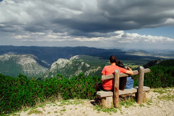 Encantador casal relaxar no pico das montanhas vista traseira — Fotografia de Stock