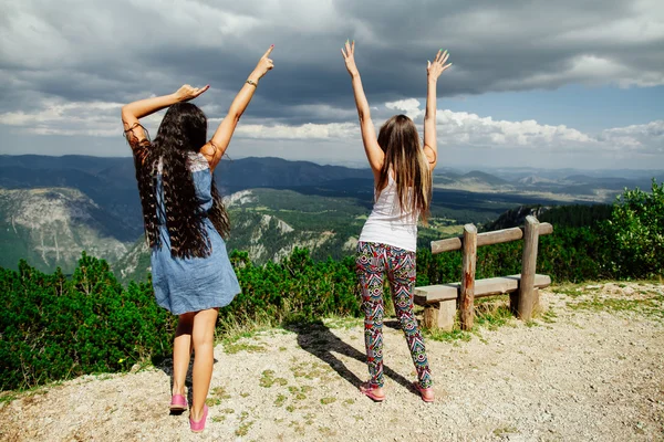 Two girls happy dance on peal of mountains — Stock Photo, Image