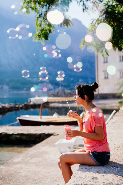 Flicka blåsa bubblor på stranden — Stockfoto