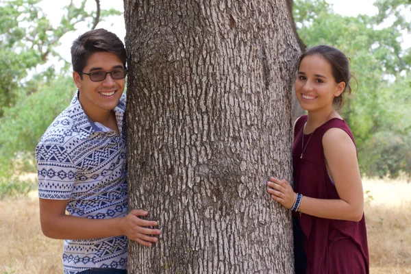 Adolescent petit ami et petite amie dans un parc à côté d'un arbre — Photo