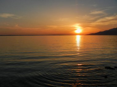 Polonya denizinin ve kumlu plajın üzerinde güzel bir gün batımı