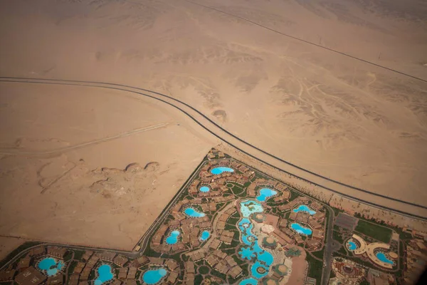 View from the plane to the Sahara desert and the resort with swimming pools at the same time