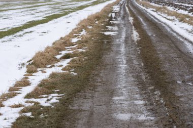 Çamur tarlası yolu kışın sonlarına doğru karlı tarlalarda akıyor.