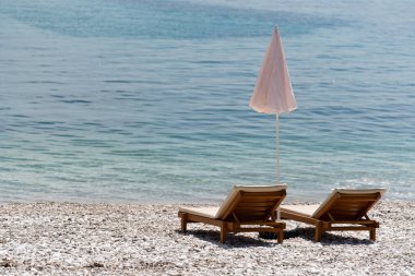 Deniz kıyısında güneşlenmenin altında güneşlenirler.