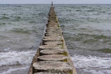 Deniz dalgaları eski bir ahşap dalgaya çarpıyor.