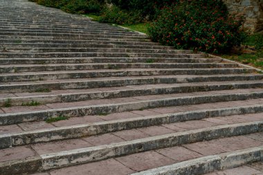 Çalılar ve yosunlarla çevrili eskimiş taş merdivenler, biraz fazla gelişmiş Toskana dış mekanı..
