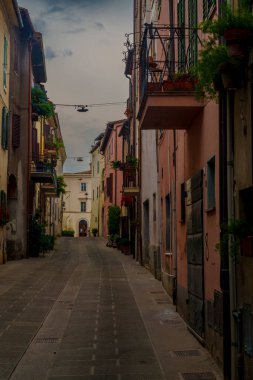 Sessiz kaldırımlı sokak, tarihi binalar, balkonlar ve bitkiler, kemer yoluna, sabah ışığına çıkar..