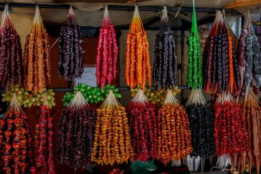 Çeşitli Gürcistan kilisesi üzümleri ve fındık şekerleri geleneksel gıda pazarında canlı sıralarda asılı