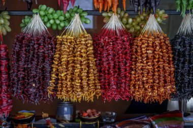 Sıralar dolusu Gürcistan kilisesi fındık tatlıları taze üzümlerin üzerinde asılı.