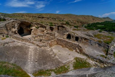 Taş teraslar, mağaralar ve Uplistsikhe mağara duvarları çorak yamaçtan aşağı taşar..