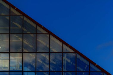 Modern mimari cam üçgen tavan yansımalı açık mavi gökyüzüne karşı