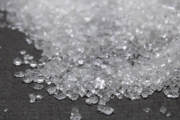 A pile of sweet sugar on a black background close-up. Macrophotography.