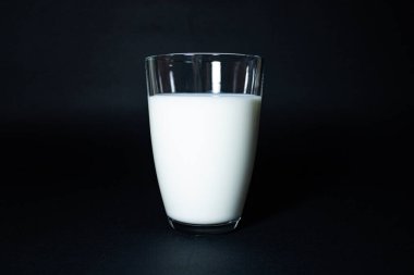  Siyah arka planda bir bardak süt..