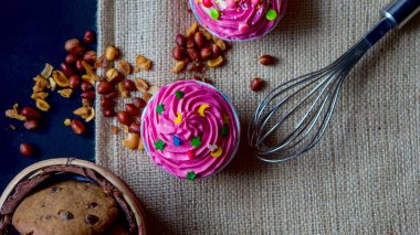 Farklı şekillerde şirin, renkli, minik kaplamalı Cupcakes 'in üst görüntüsü. Çuval bezine yakın çekim yap. Kullanılabilir metin ve kopyalama alanı.