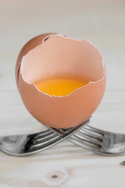 Huevo roto descansa sobre dos tenedores —  Fotos de Stock