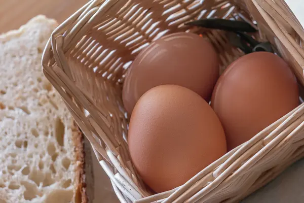 Huevos en la cesta, y rebanadas de pan —  Fotos de Stock