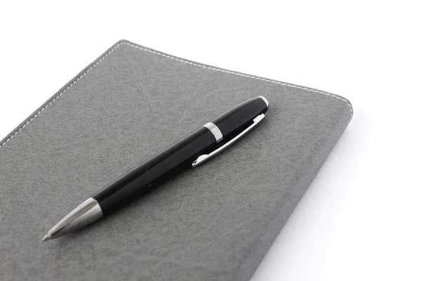 Дневник книги и ручка на изолированном фоне — стоковое фото