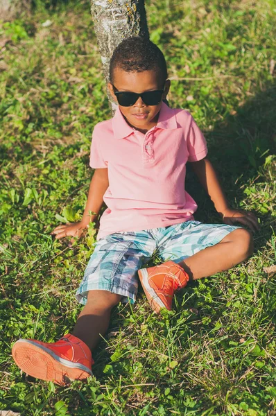 Çimenlerin üzerinde oturan Afro American boy — Stok fotoğraf