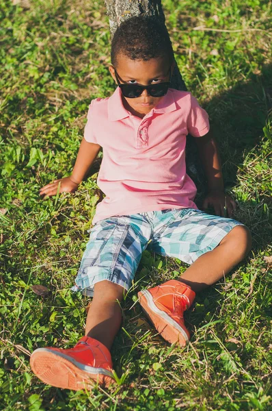 Çimenlerin üzerinde oturan Afro American boy — Stok fotoğraf