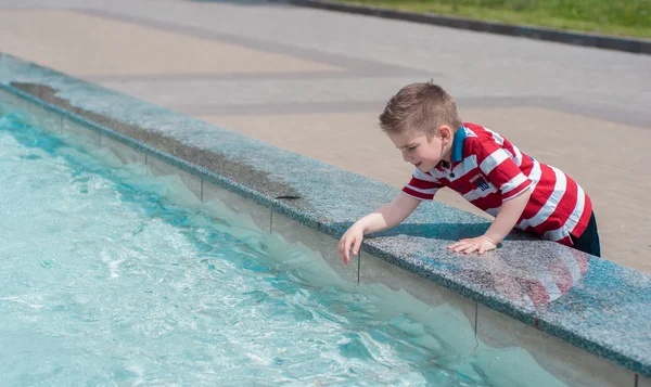 Çocuk suyla oynuyor.