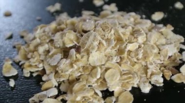 Siyah zemin üzerinde dönen küçük bir yulaf ezmesi, makro çekim