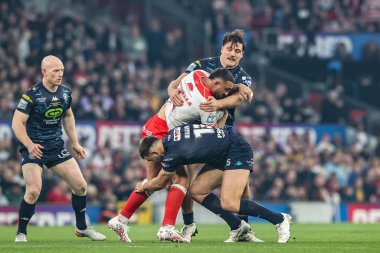 Elliot Minchella of Hull KR is tackled by Kaide Ellis of Wigan Warriors and Liam Byrne of Wigan Warriors during the 2025 Betfred Super League Grand Final Hull KR v Wigan Warriors at Old Trafford, Manchester, United Kingdom, 11th October 2025 