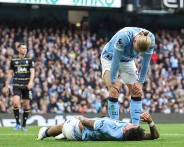 Manchester City 'den Erling Haaland, Manchester City' nin 18 Ekim 2025 tarihinde Etihad Stadyumu 'nda oynanan Premier League karşılaşmasında Everton' dan James Tarkowski ile karşılaştıktan sonra Manchester City 'den Nico O' Reilly 'yi kontrol ediyor. 