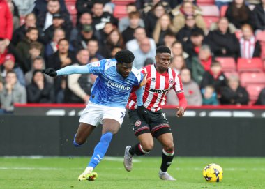 Derby County 'den Patrick Agyemang ve Sheffield United takımından Chiedozie Ogbene, 1 Kasım 2025' te Bramall Lane, Sheffield, İngiltere 'de oynanan Sky Bet Şampiyonası maçında top için mücadele ettiler. 