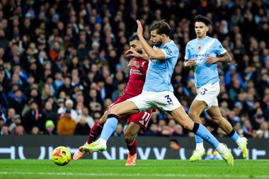 Liverpool 'dan Muhammed Salah, Manchester City' nin 9 Kasım 2025 'te Etihad Stadyumu' nda Liverpool 'a karşı oynadığı Premier Lig karşılaşmasında Manchester City' den Ruben Dias 'ın baskısı altında şut çekti. 