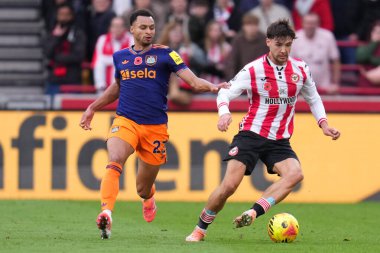 Brentford 'dan Aaron Hickey, 9 Kasım 2025' te İngiltere 'deki Gtech Community Stadyumu' nda oynanan Premier League maçı sırasında Newcastle United 'dan Jacob Murphy' nin baskısı altında topa vuruyor. 