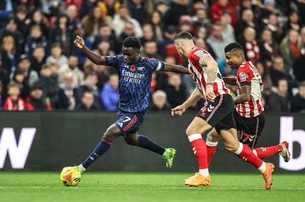 Arsenal 'den Bukayo Saka, Sunderland' dan GranitXhaka ve Sunderland 'dan Reinildo Mandava' nın 8 Kasım 2025 'te İngiltere' nin Sunderland-Arsenal Stadyumu 'nda oynanan Premier Lig karşılaşmasında topa vuruyor. 