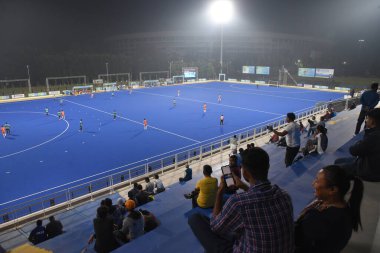 Insanlar, Hindistan Hava Kuvvetleri ile Vivekananda Yuba Bharati Hokey Stadyumu 'ndaki Canara Bank arasındaki 126. Beighton Kupası yarı final maçı sırasında 15 Kasım 2025' te Hindistan 'ın Kolkata kentinde oynanan hokey maçını izliyorlar. 