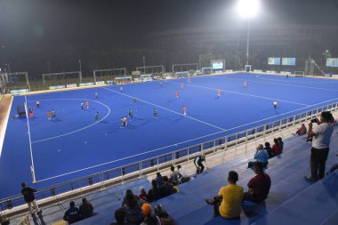 Insanlar, Hindistan Hava Kuvvetleri ile Vivekananda Yuba Bharati Hokey Stadyumu 'ndaki Canara Bank arasındaki 126. Beighton Kupası yarı final maçı sırasında 15 Kasım 2025' te Hindistan 'ın Kolkata kentinde oynanan hokey maçını izliyorlar.  