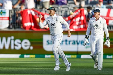 İngiltere 'nin Joe Root' u, İngiltere kaptanı Ben Stokes 'un 20 Kasım 2025' te Optus Stadyumu, Perth, Avustralya 'da oynanan NRMA Sigorta Külleri Birinci Sınav Günü Serisi' nde Sith kalesini almasını kutluyor.