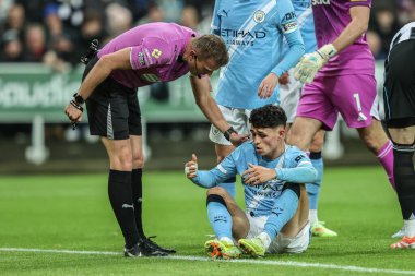 Hakem Samuel Barrott, Manchester City 'den Phil Foden' ı Premier Lig maçı Newcastle United 'a karşı Manchester City' de 21 Kasım 2025 'te St. James' s Park 'ta sakatlanırken kontrol ediyor.