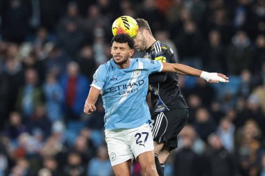 Manchester City 'den Matheus Nunes 29 Kasım 2025 tarihinde Etihad Stadyumu, Manchester, İngiltere' de oynanan Premier League maçında Leeds United 'dan Gabriel Gudmundsson' dan yüksek topu almak için sıçradı. 